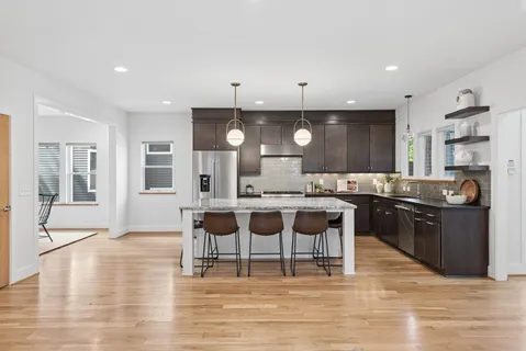 a kitchen with a sink and chairs