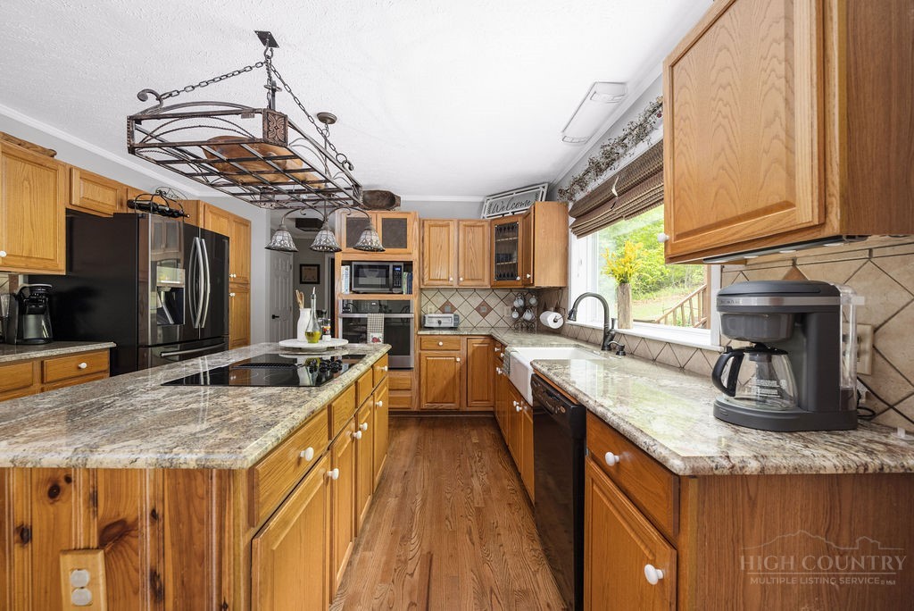 970 Vox Road Sparta, NC 28675 - Photo 22 of 50 a kitchen with stainless steel appliances granite countertop a sink a stove and a wooden floors