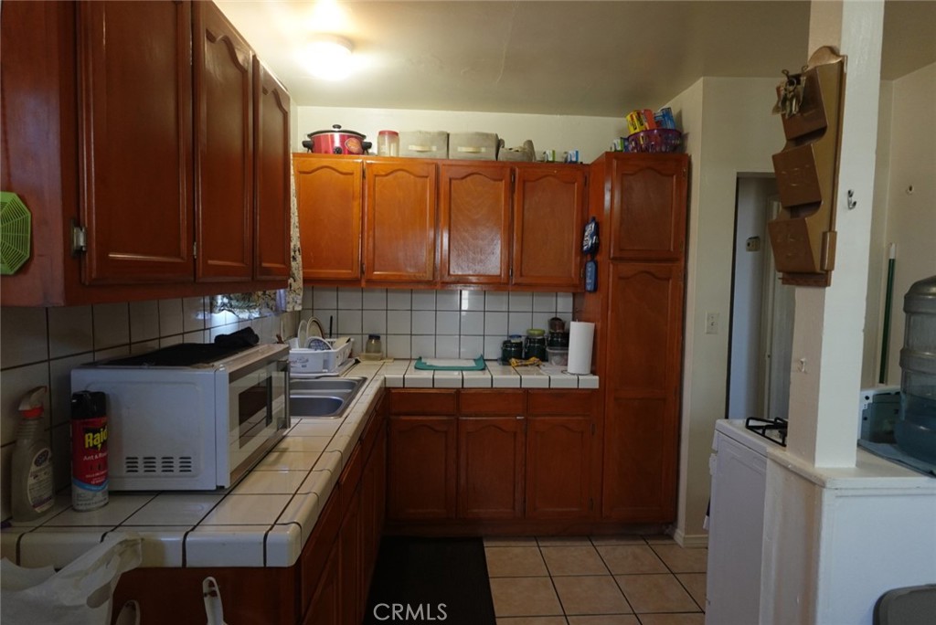 533 West Almond Street Compton, CA 90220 - Photo 2 of 5 a kitchen with stainless steel appliances a refrigerator sink and cabinets