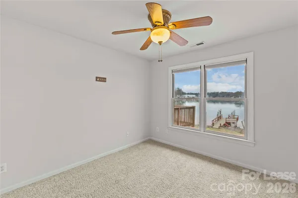 an empty room with window and ceiling fan