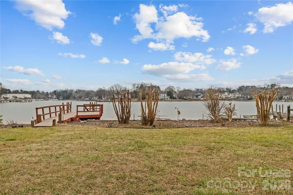 a view of a house with a big yard and large trees