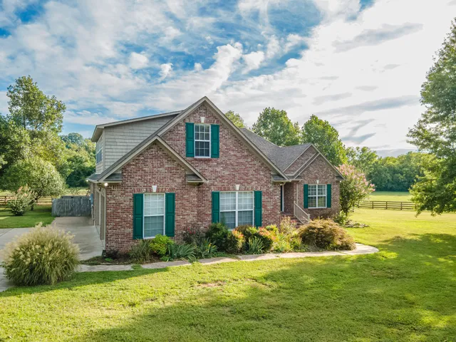 a kitchen with stainless steel appliances granite countertop a refrigerator a stove a sink a dining table and chairs with wooden floor