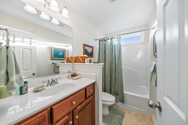 a backyard of a house with plants and trees with wooden fence