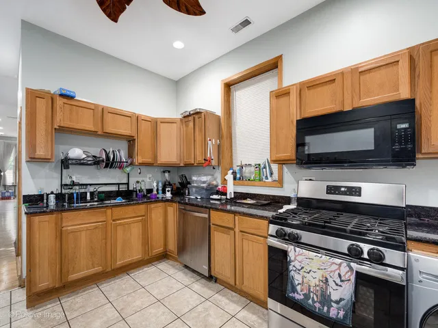 a kitchen with stainless steel appliances a stove sink microwave and cabinets