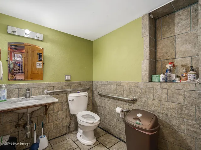 a bathroom with a granite countertop toilet sink and mirror