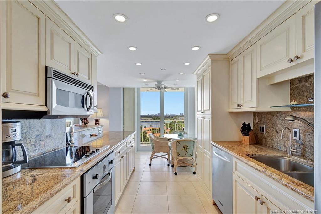 500 Ocean Drive, Unit W11 North Palm Beach, FL 33408 - Photo 17 of 77 a kitchen with stainless steel appliances granite countertop a sink stove and cabinets
