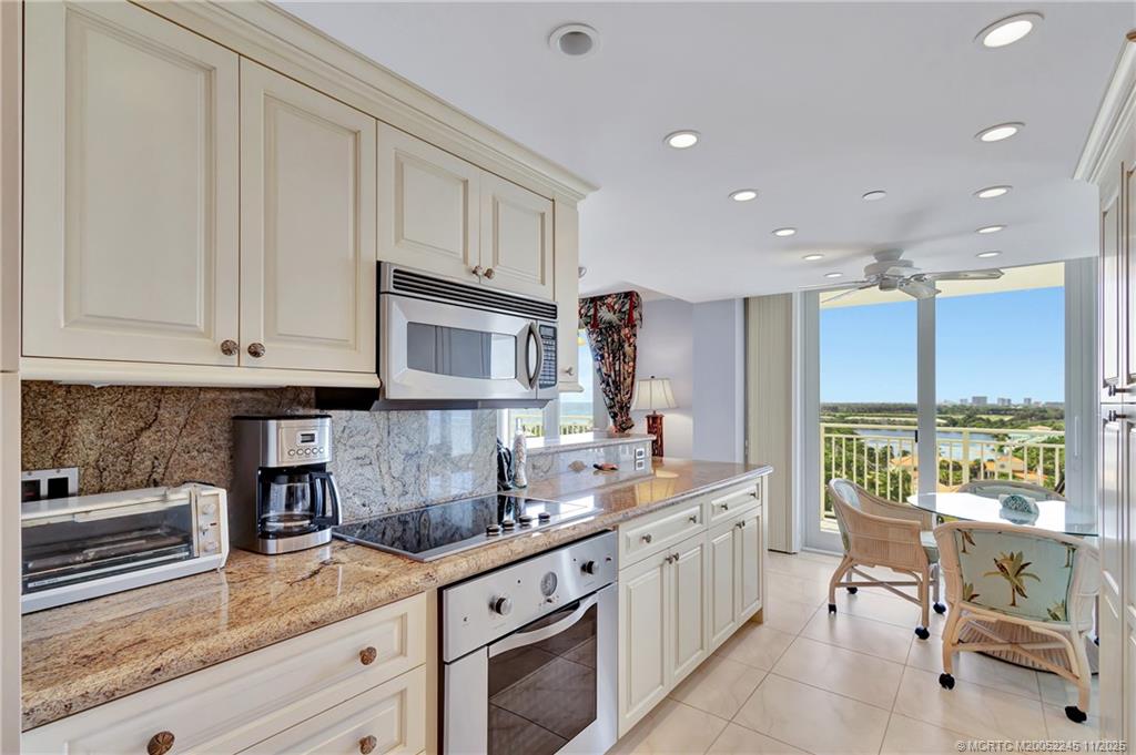 500 Ocean Drive, Unit W11 North Palm Beach, FL 33408 - Photo 20 of 77 a kitchen with stainless steel appliances granite countertop a stove a sink and white cabinets with wooden floor