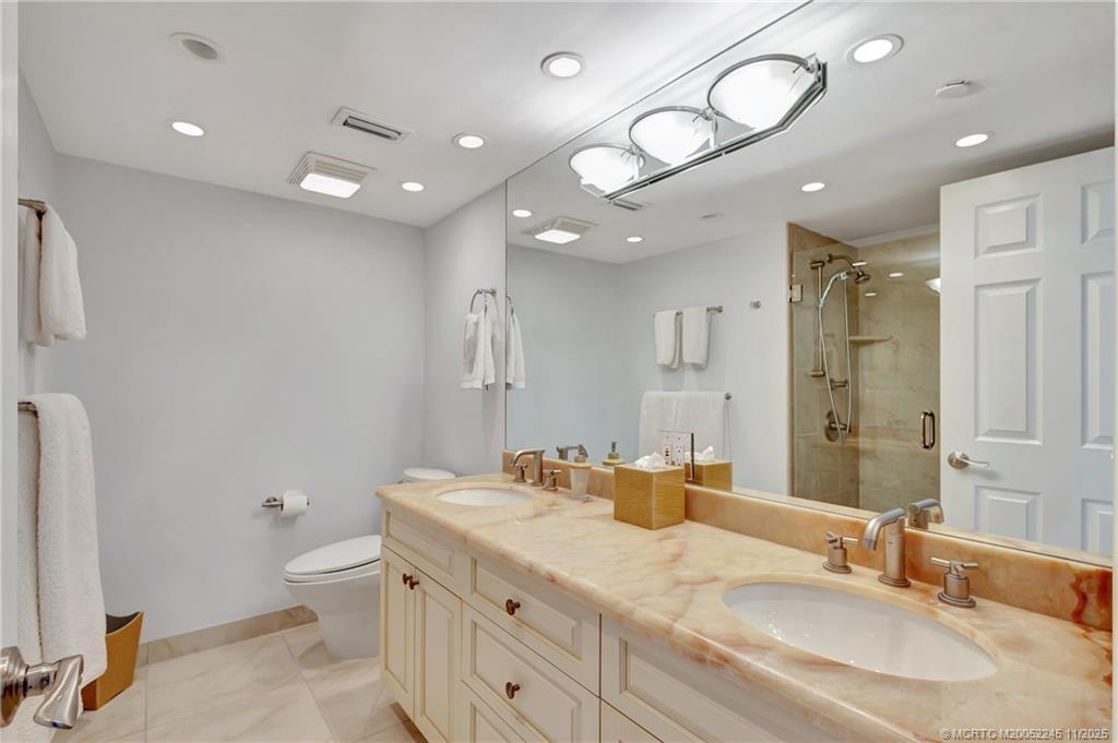 500 Ocean Drive, Unit W11 North Palm Beach, FL 33408 - Photo 33 of 77 a bathroom with a granite countertop sink a toilet and a mirror