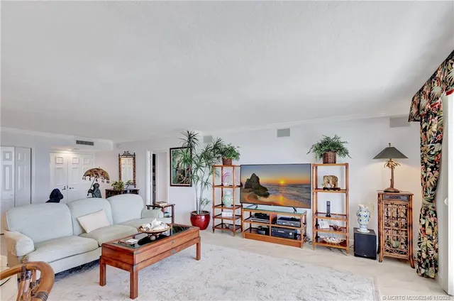 a living room with furniture and a dining table with wooden floor