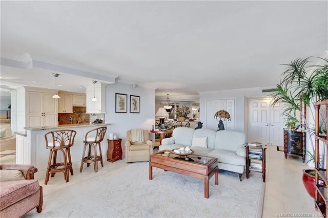a view of a dining room and livingroom with furniture wooden floor a chandelier