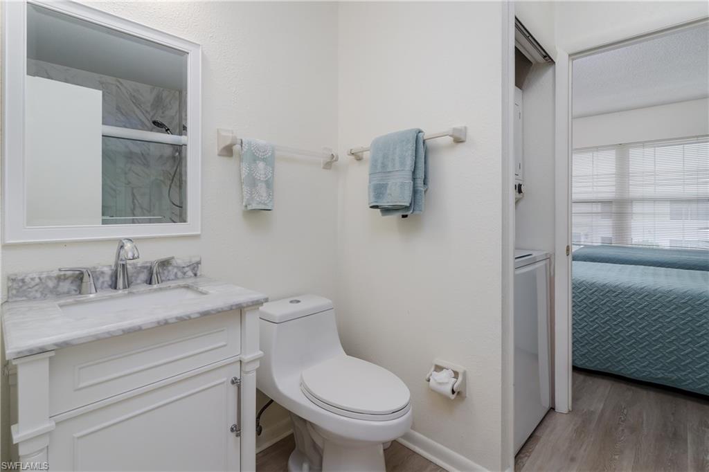 116 Clyburn Street, Unit C6 Marco Island, FL 34145 - Photo 17 of 32 a bathroom with a granite countertop toilet sink and mirror