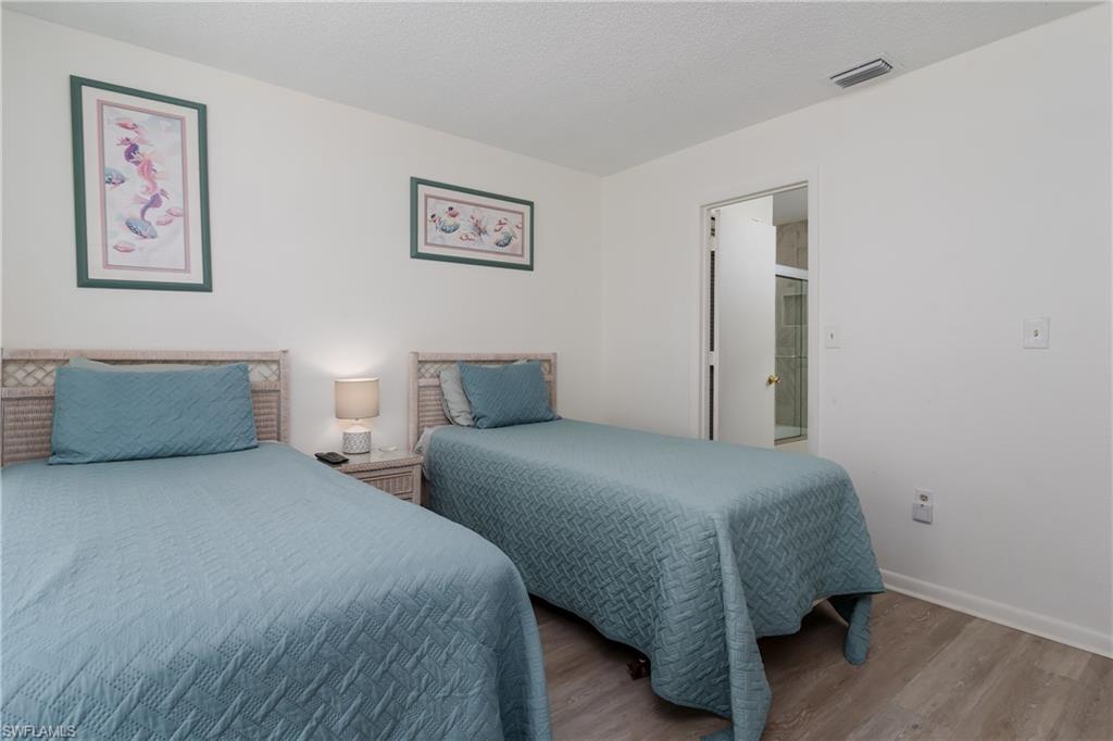 116 Clyburn Street, Unit C6 Marco Island, FL 34145 - Photo 20 of 32 a bedroom with two beds and a lamp on dresser