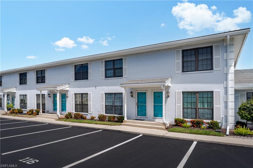 116 Clyburn Street, Unit C6 Marco Island, FL 34145 - Photo 23 of 32 a front view of a building with lots of windows and trees