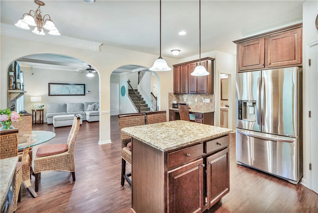 144 Buckland Drive Anderson, SC 29621 - Photo 36 of 48 A chef's kitchen boasts granite counters, stainless steel appliances, and an inviting island, flowing into a living area.