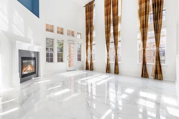 a view of an empty room with a fireplace and a window