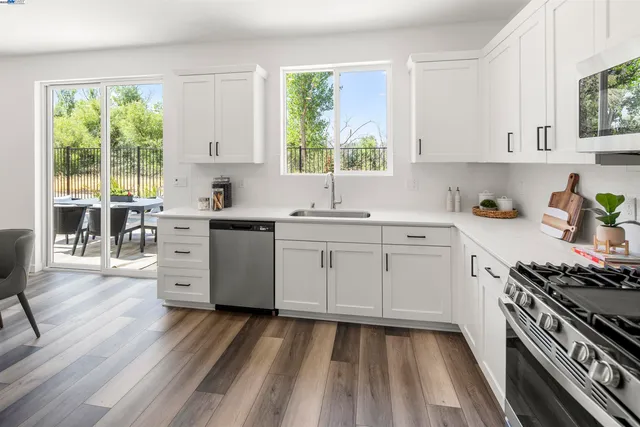 a kitchen with a sink stove window and cabinets