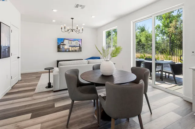 a view of a dining room with furniture large windows and wooden floor