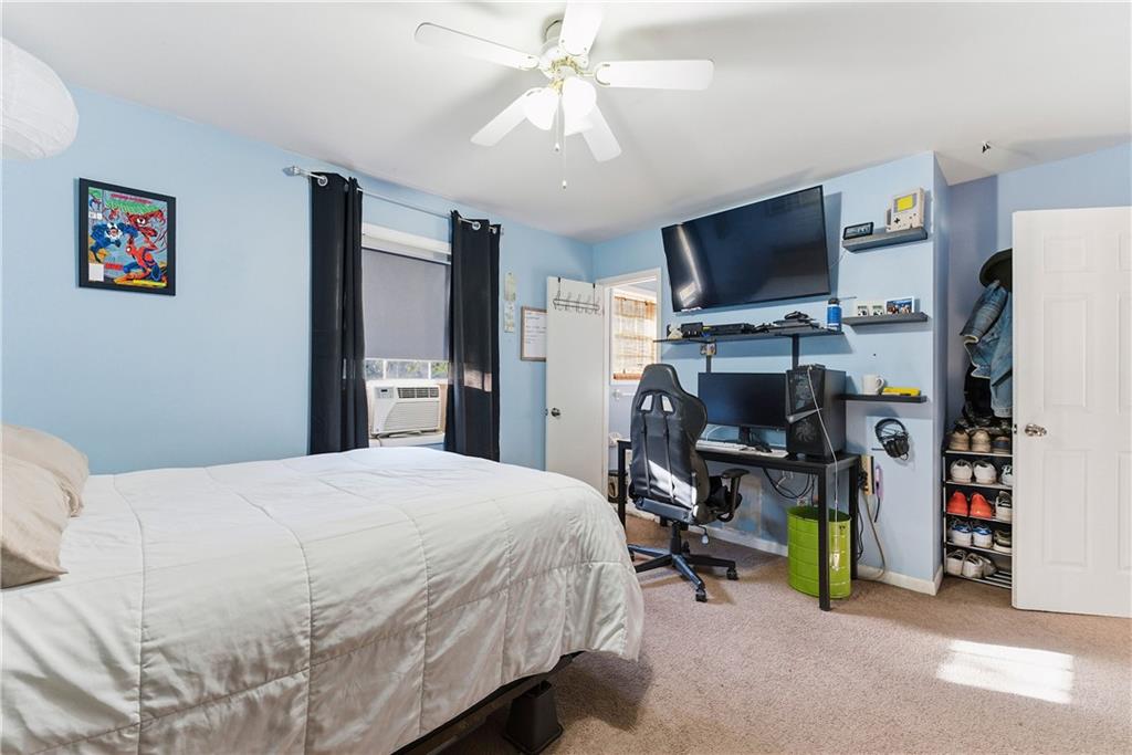 3033 Thrasher Circle Decatur, GA 30032 - Photo 14 of 25 a bedroom with a bed a flat screen tv and a chandelier