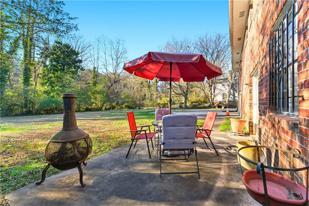 3033 Thrasher Circle Decatur, GA 30032 - Photo 23 of 25 a view of a swimming pool with a table and chairs under an umbrella