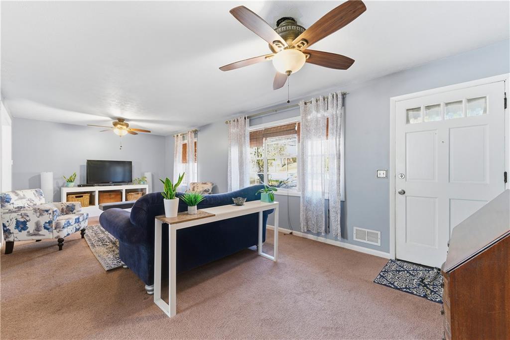 3033 Thrasher Circle Decatur, GA 30032 - Photo 5 of 25 a living room with furniture a chandelier fan and a window