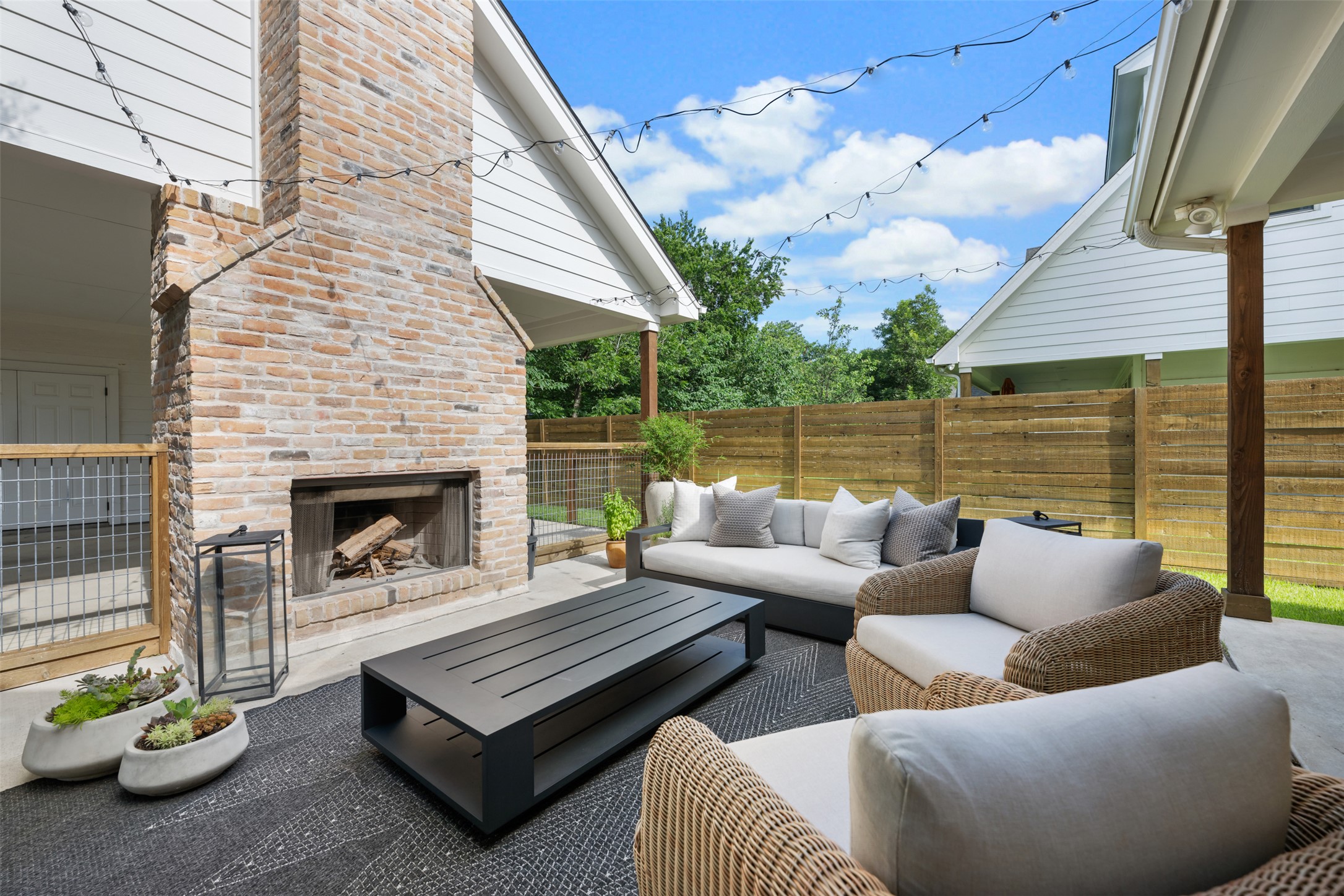 1301 West Street Georgetown, TX 78626 - Photo 38 of 40 An inviting outdoor living space features a brick fireplace, patio, and privacy fence for serene gatherings.