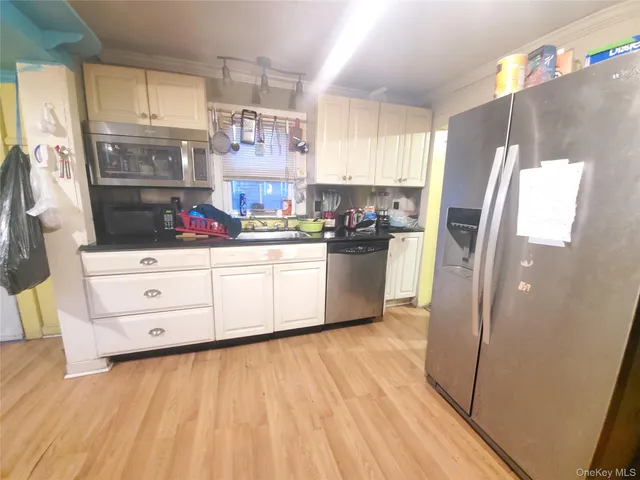 a kitchen with stainless steel appliances a refrigerator sink and cabinets