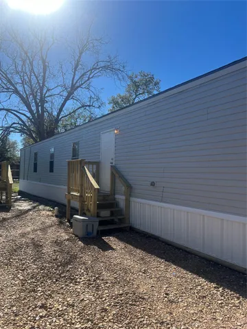a view of backyard with barbeque grill and wooden fence