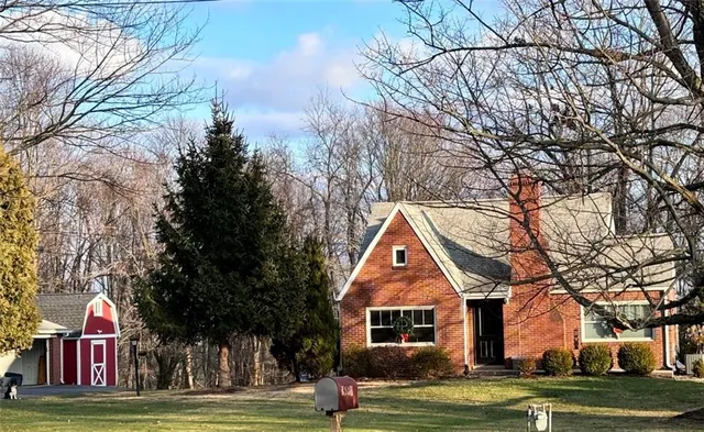 a front view of residential houses with yard and trees around