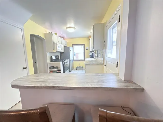a kitchen with granite countertop white cabinets and white appliances