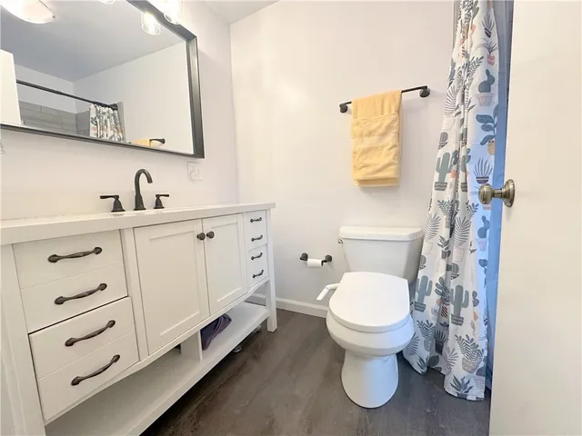 a spacious bedroom with a bed and wooden floor