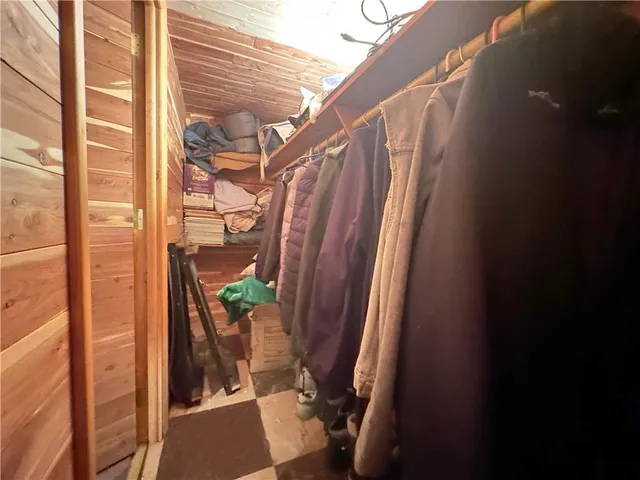 a bedroom with a bed a mirror and next to a window