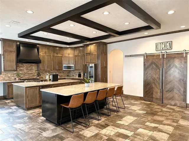 a kitchen with stainless steel appliances kitchen island granite countertop a sink and cabinets