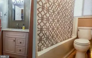 a bathroom with a granite countertop toilet and a sink