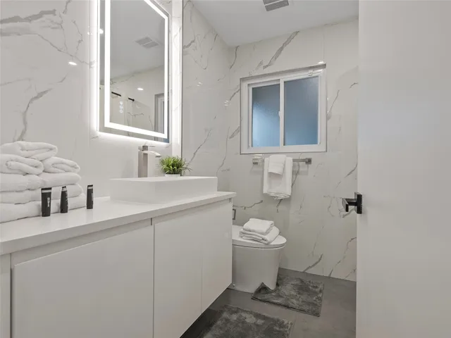 a bathroom with a sink toilet and mirror
