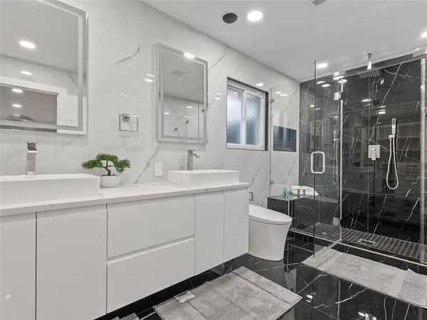 a bathroom with a double vanity sink mirror and toilet