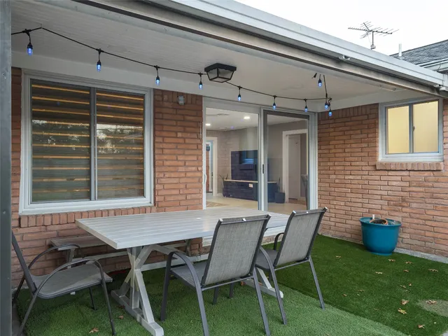a view of a patio with table and chairs