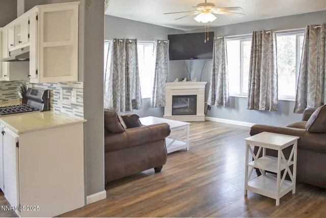 a living room with furniture a fireplace and a window