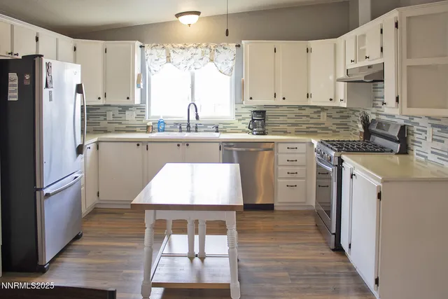 a kitchen with stainless steel appliances granite countertop a stove a sink dishwasher and a refrigerator