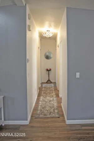 a view of a hallway with wooden floor and staircase