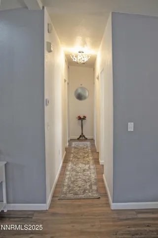 a view of a hallway with wooden floor and staircase