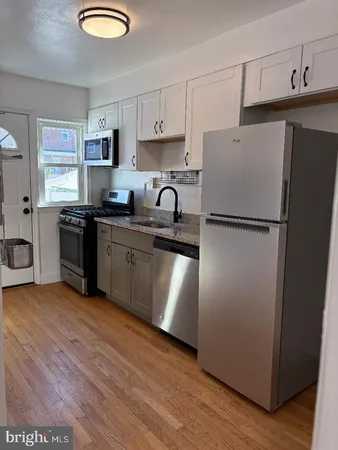 a kitchen with stainless steel appliances granite countertop a refrigerator sink and stove