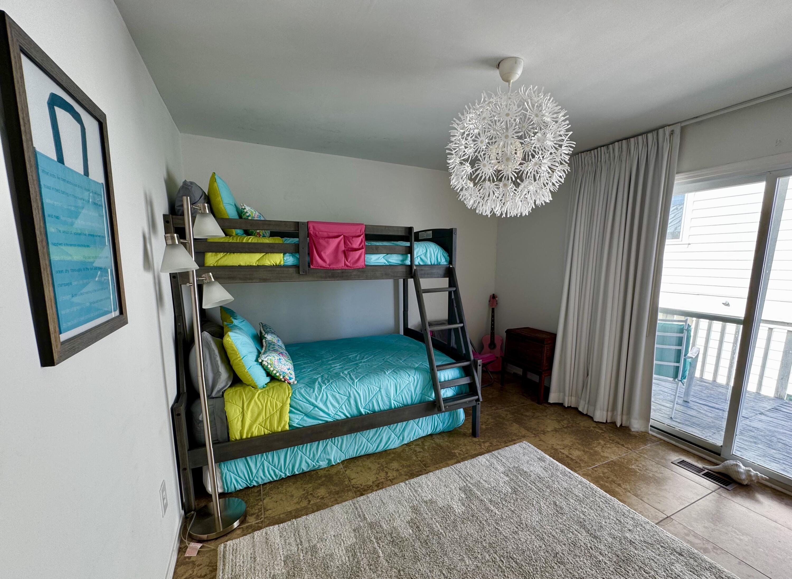 228 Walton Magnolia Lane, Unit 9 Inlet Beach, FL 32461 - Photo 18 of 24 a bedroom with a bed and a chandelier