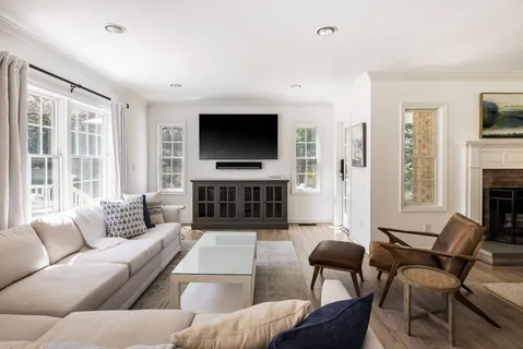 a living room with furniture a flat screen tv and a fireplace