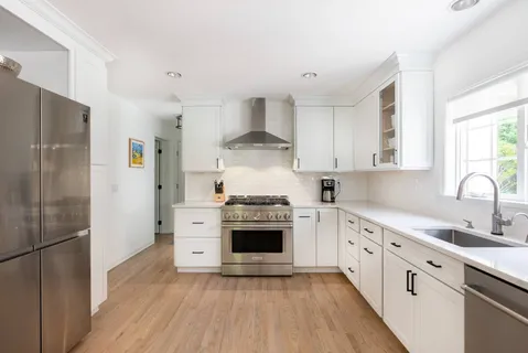 a kitchen with stainless steel appliances a stove a sink and a refrigerator