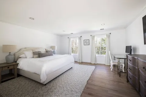 a spacious bedroom with a bed and a table in it