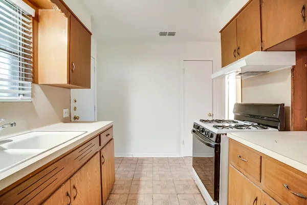 a kitchen with a sink stove top oven and cabinets