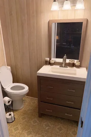 a bathroom with a toilet a sink and mirror