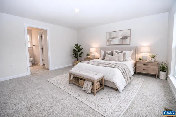 a spacious bedroom with a bed and a lamp