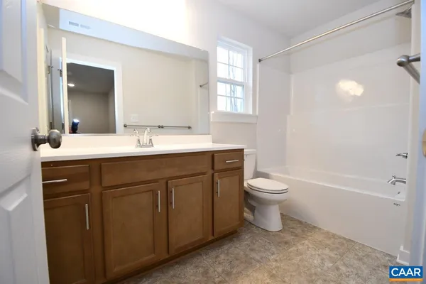 a bathroom with a toilet a sink a tub and mirror