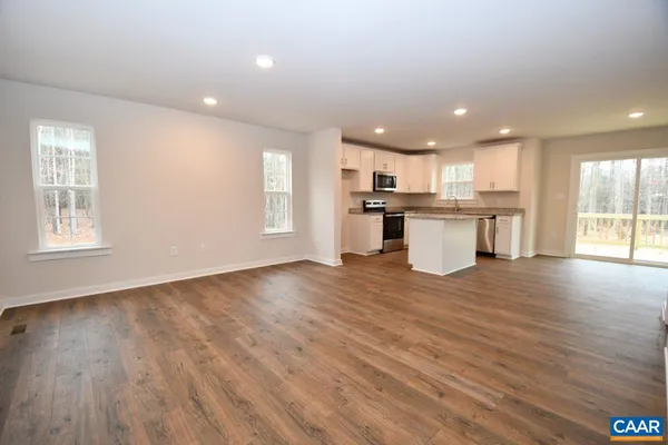 a open kitchen with kitchen island a sink dishwasher stove with wooden floors